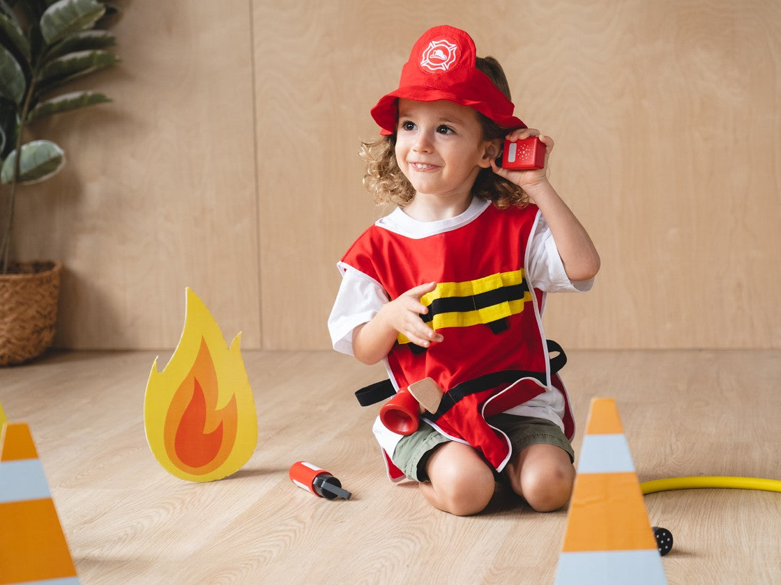 child playing with the Fire Fighter Play Set by Plan Toys