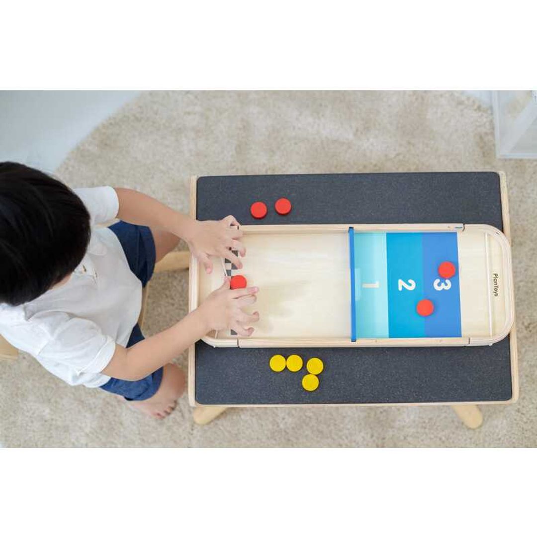 Child playing Shuffleboard-Game by Plan Toys