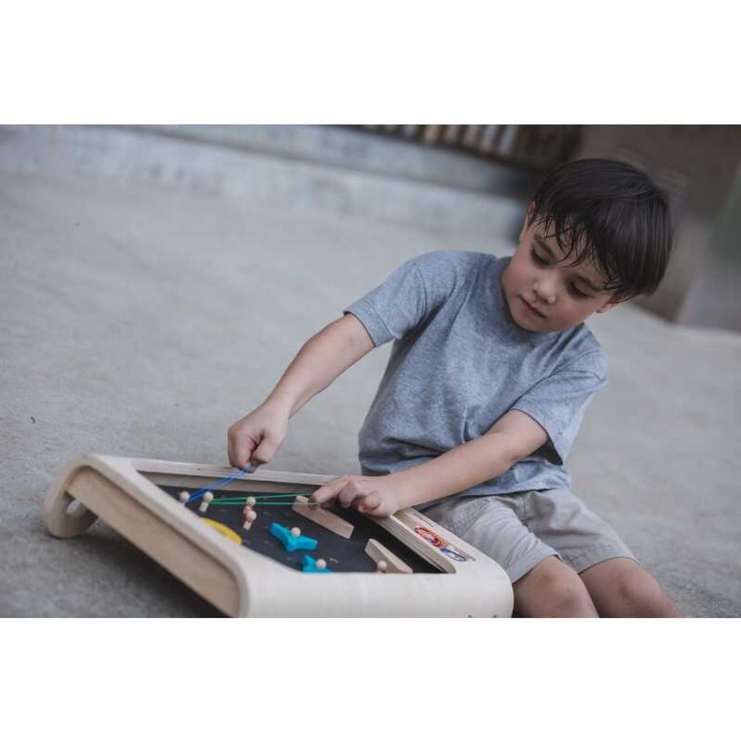 Child Playing Pinball Set by Plan Toys