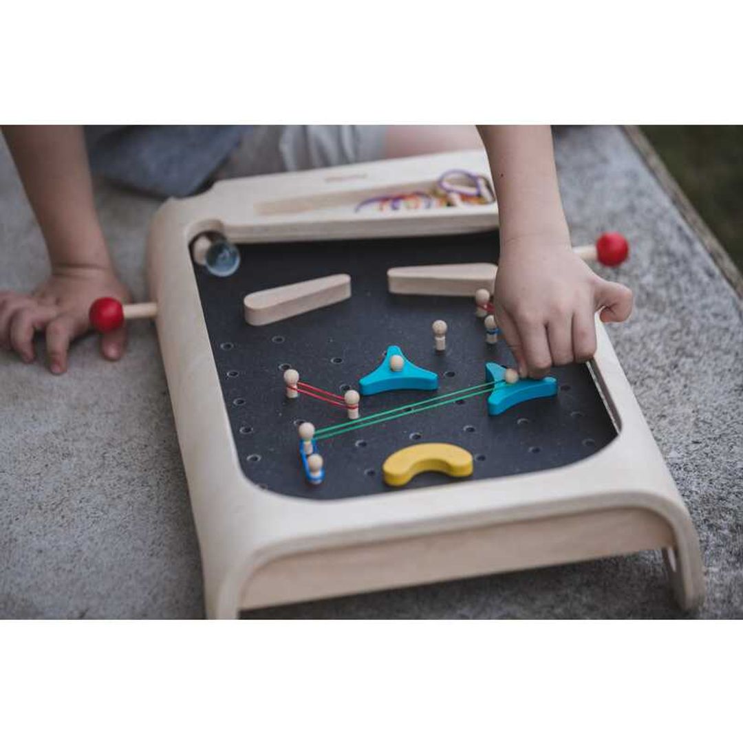 Child Playing Pinball Set by Plan Toys