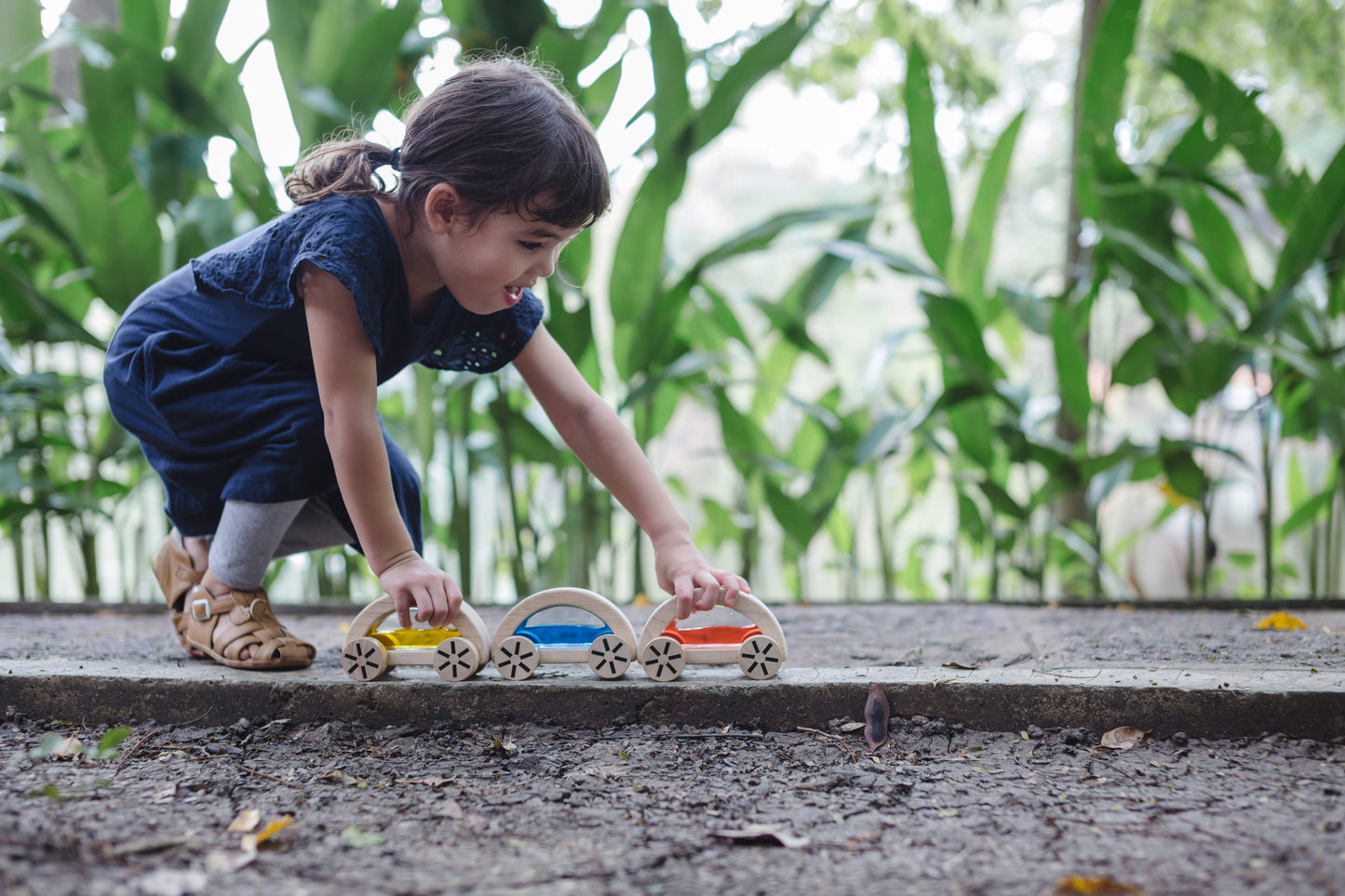 Child playing with wautomobiles outside