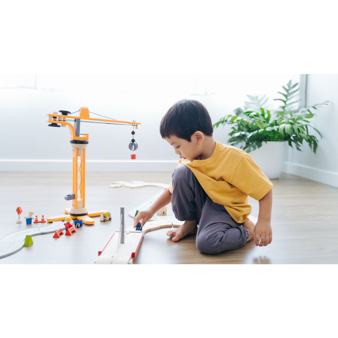 Child playing with Plan Toys Crane Set
