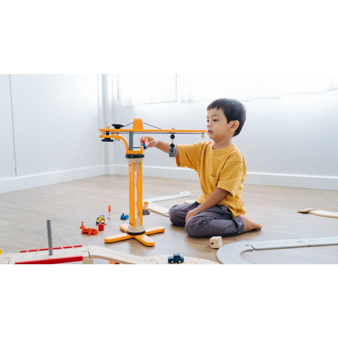 Child playing with Plan Toys Crane Set
