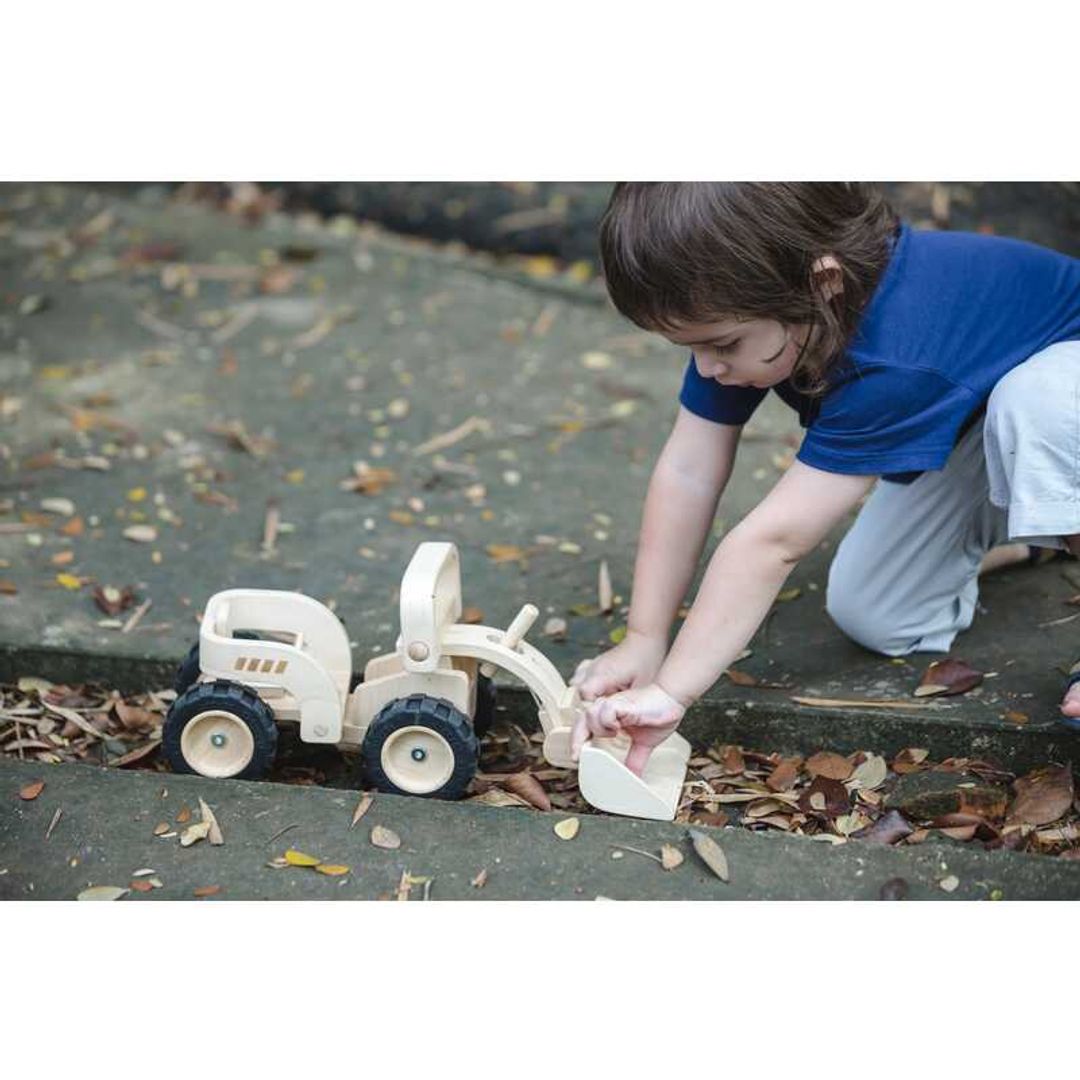 child playing with a Bulldozer by Plan Toys