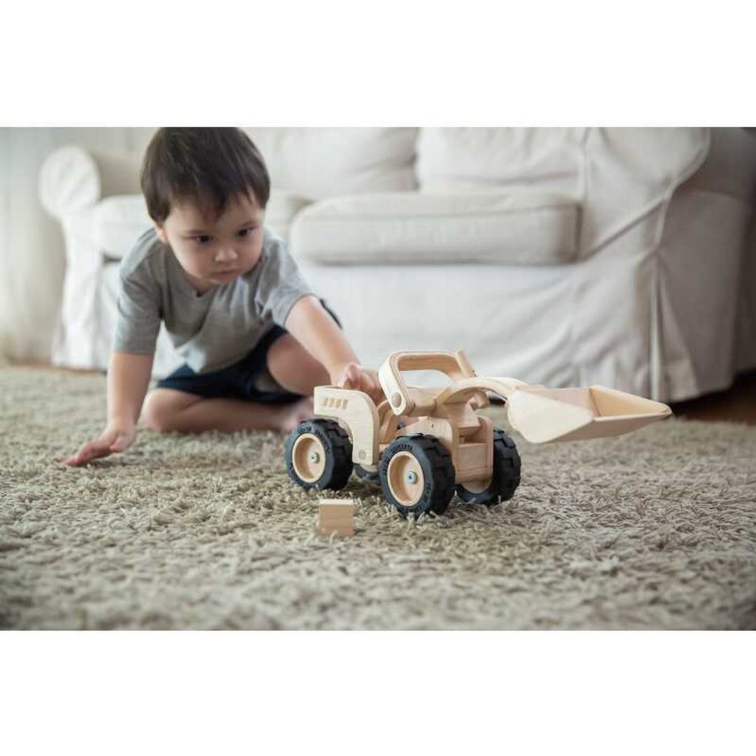 toddler pushing the Bulldozer by Plan Toys