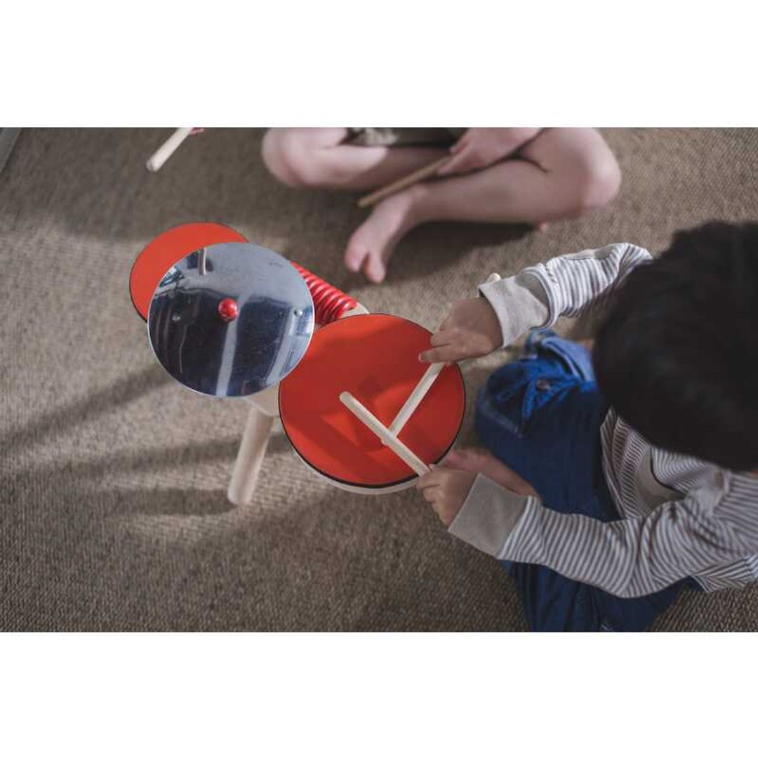 Kids playing with Musical Band Drum Kit by Plan Toys
