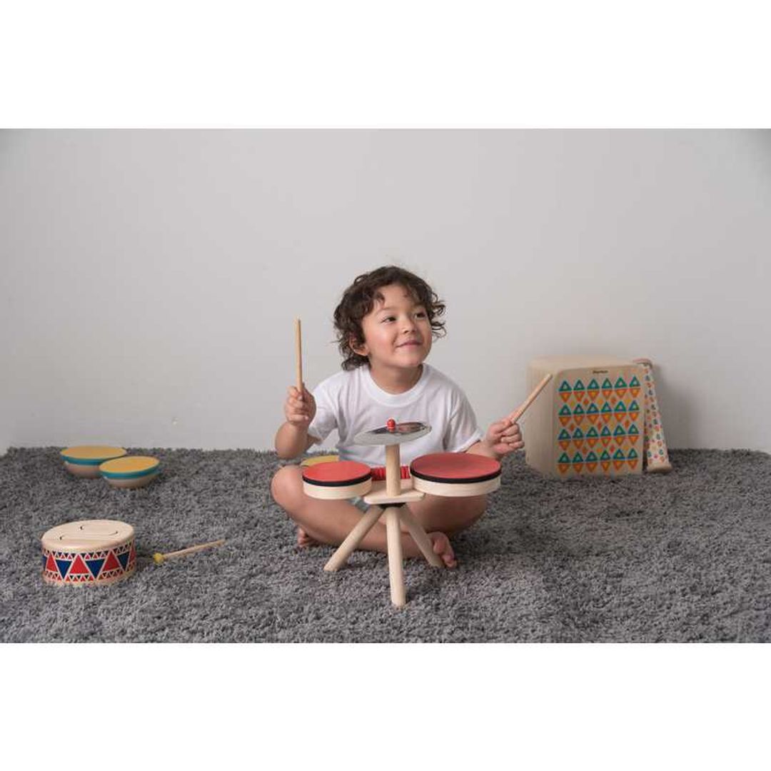 kids playing with Musical Band Drum Kit by Plan Toys