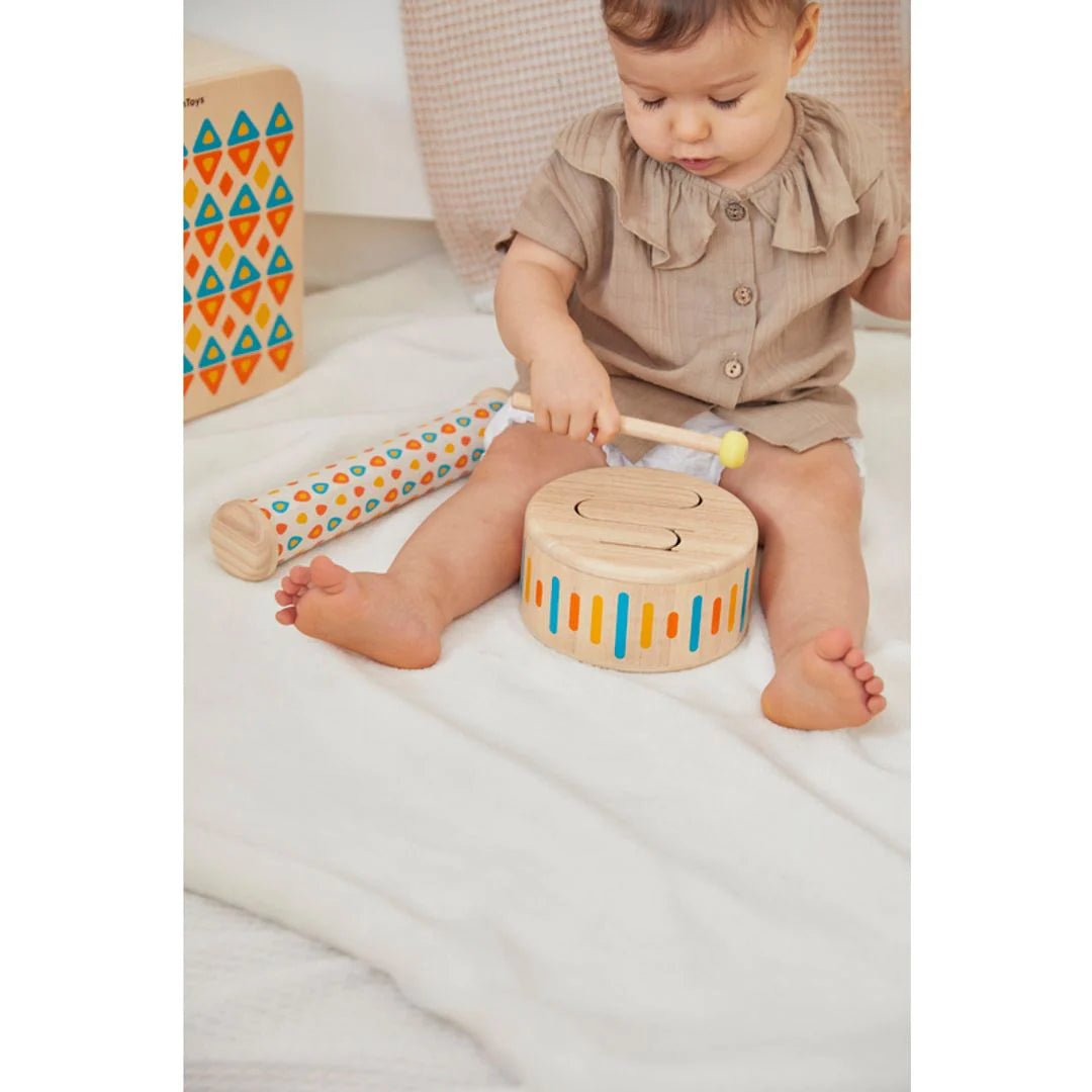 Baby playing with solid drum II by PlanToys