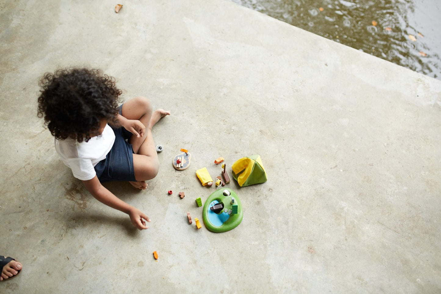 Child plying with a Camping Set by Plan toys