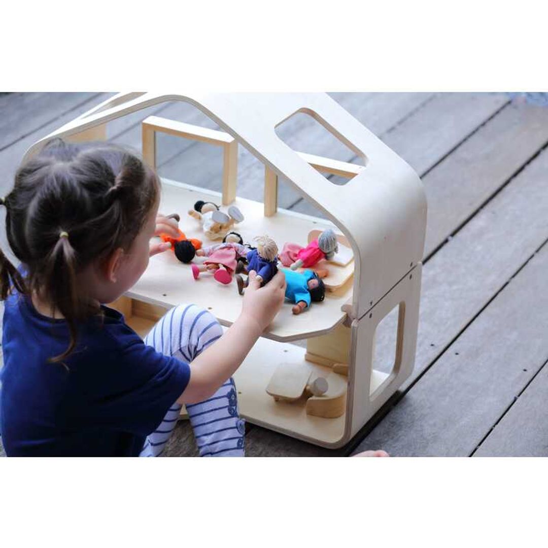 child playing with a Contemporary Dollhouse by Plan Toys