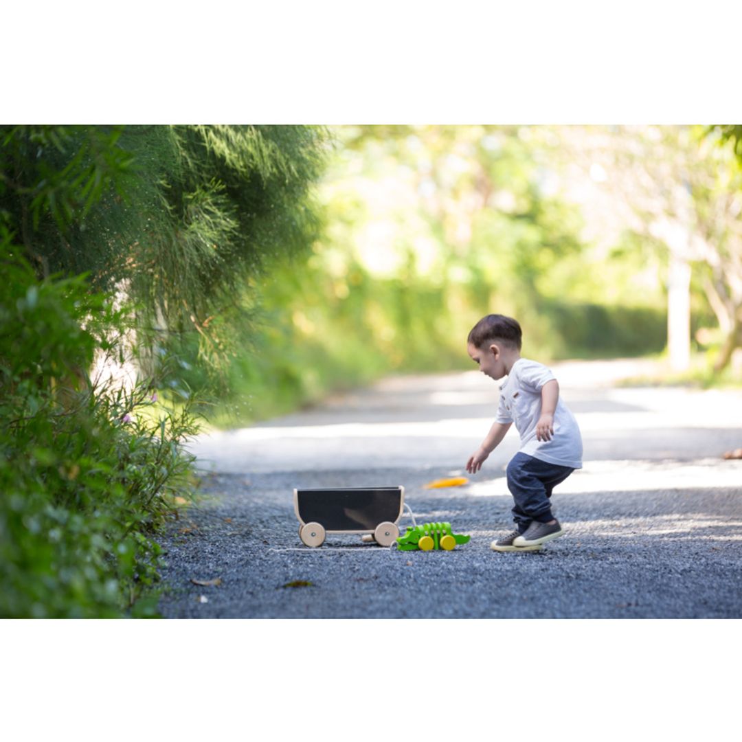 Child playing outside Kids with Black Wagon  by Plan Toys