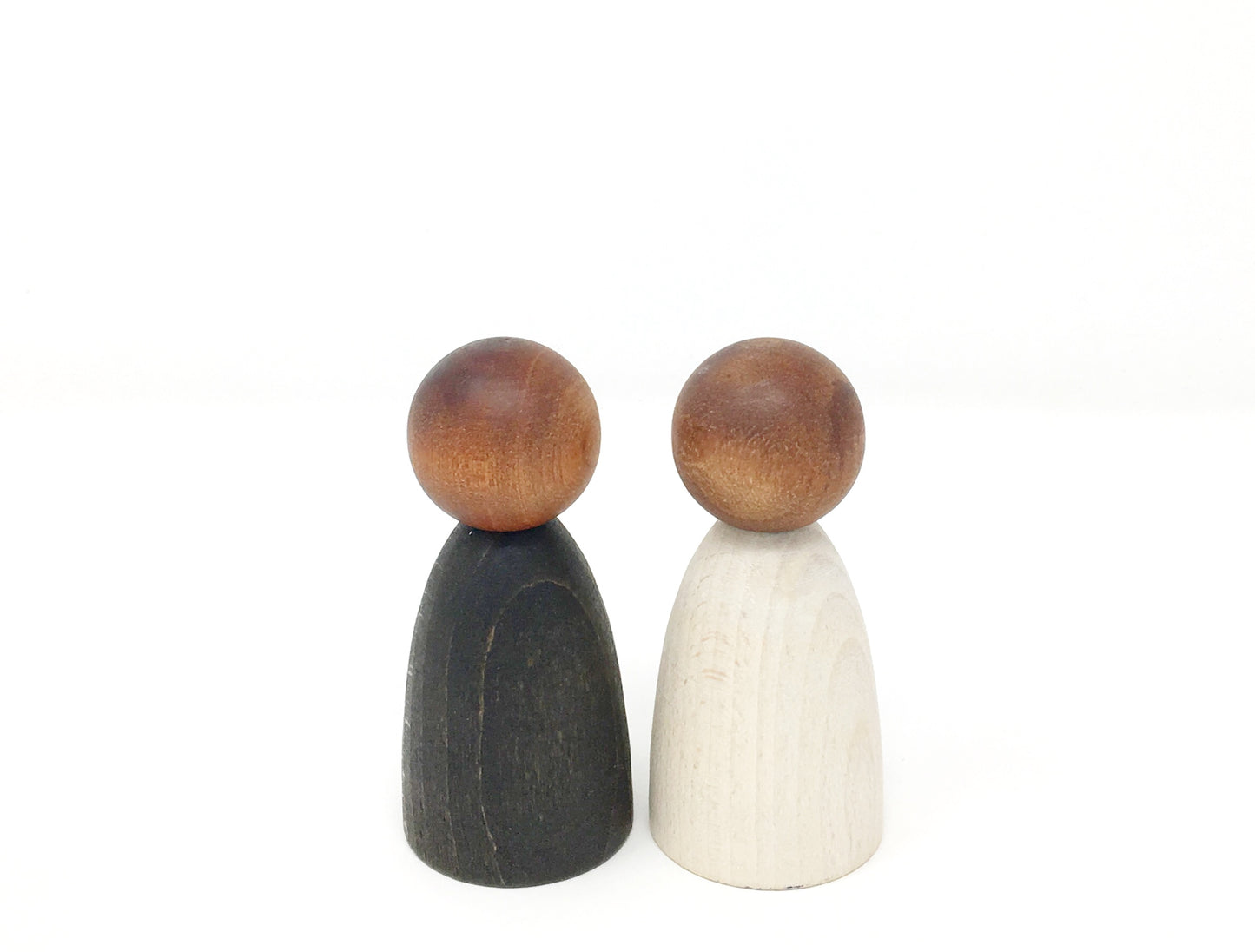 Two wooden peg people, one painted in black and the other in white.