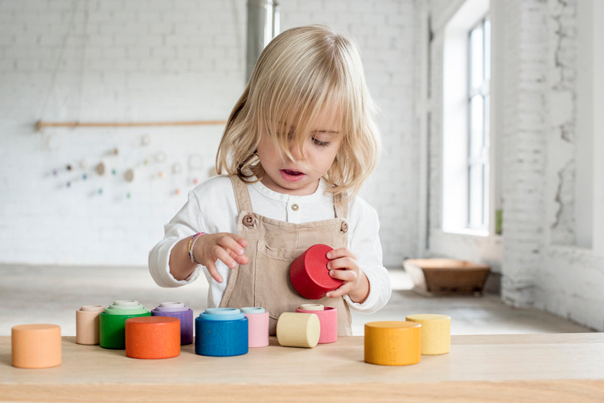 Child playing with nesting bowls by Grapat