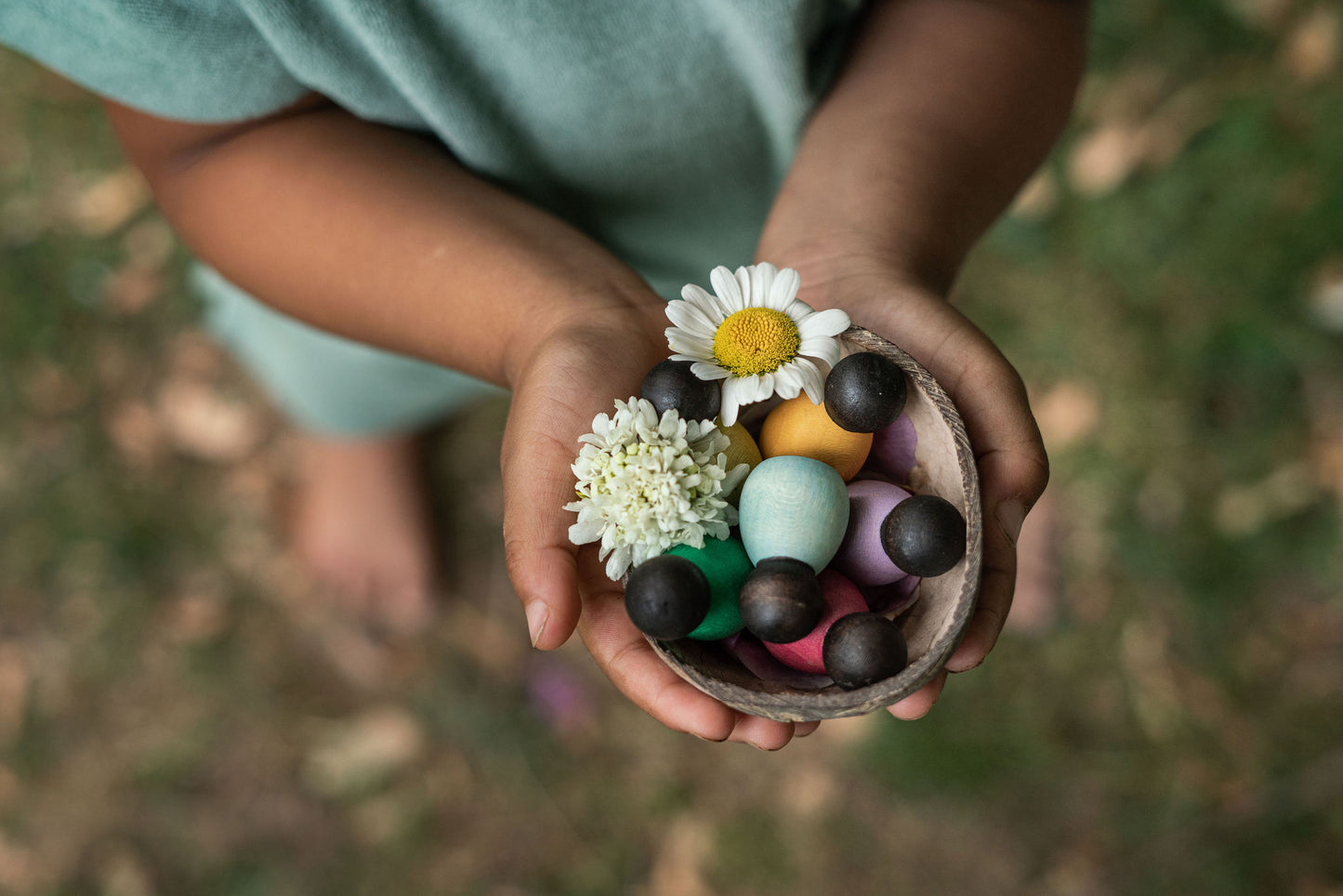 Child with dark baby nins in coconut shell in their hands