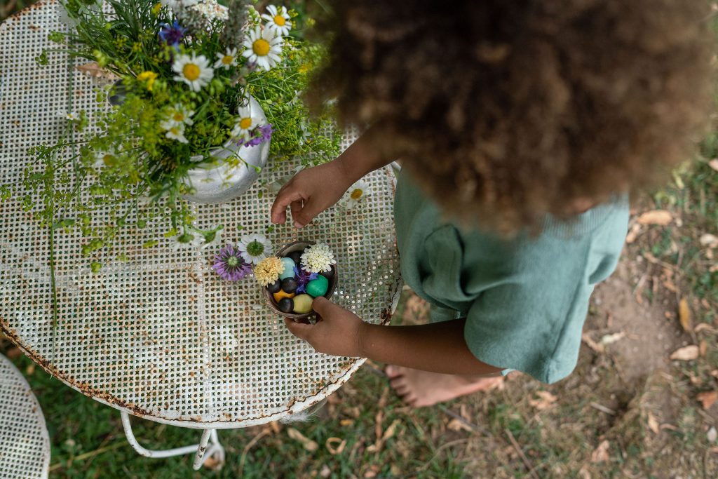 Child playing with dark baby nins and flowers