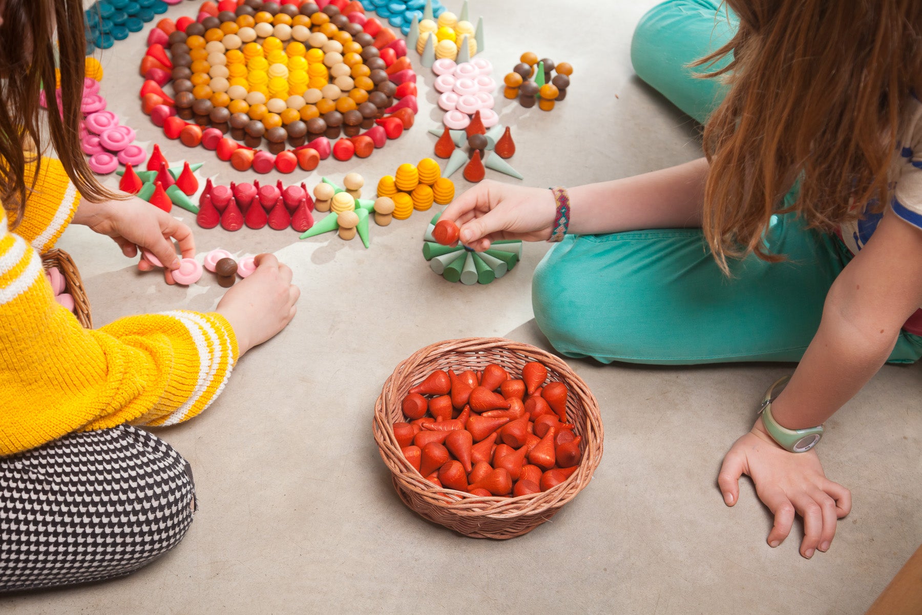 Children playing with Grapat mandalas, with fire mandala in a basket