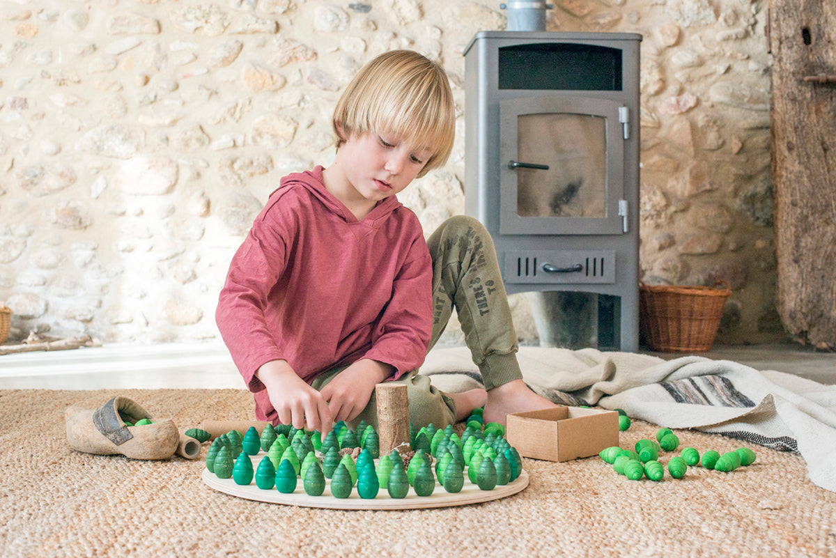 Child playing with tree mandala on a round wooden platform