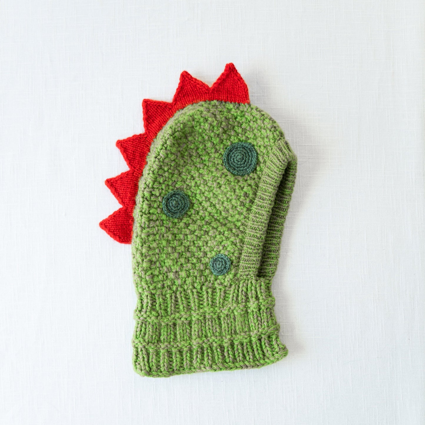 Dinosaur knitted hood flat lay