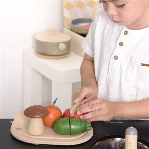 child playing with an Assorted Vegetables Set by plan toys