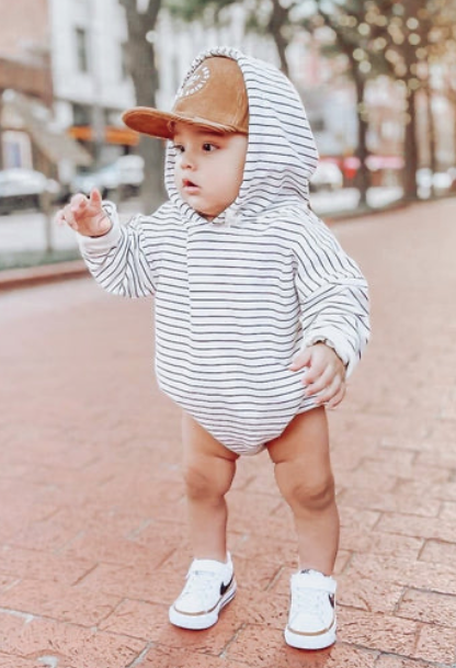 Baby walking outdoors wearing striped baby hoody