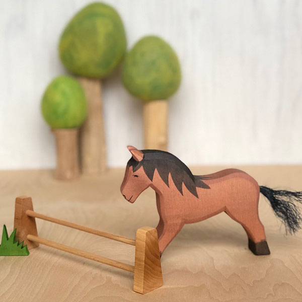 Scene with spring wool felt trees a fence a brown horse and a bit of grass