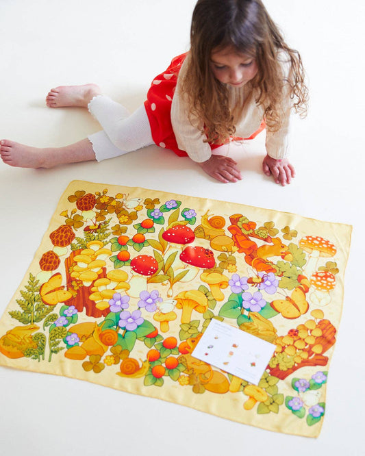 Child on the floor playing with Mushroom Print Seek & Find Playsilk
