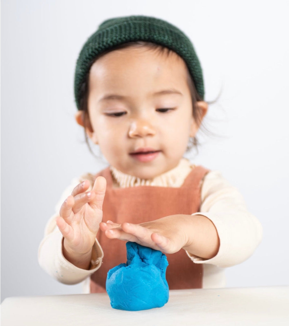 kid playing with blue eco play dough