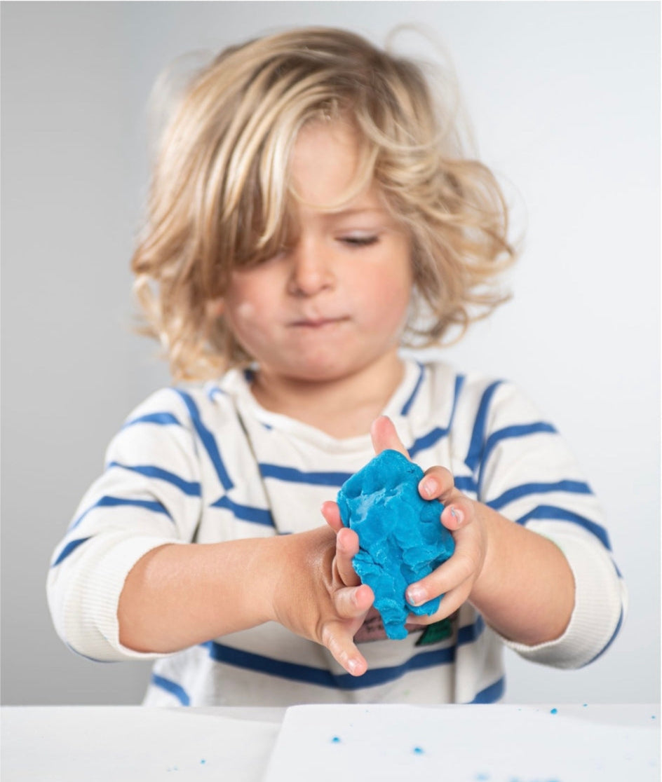 kid playing with blue eco play dough