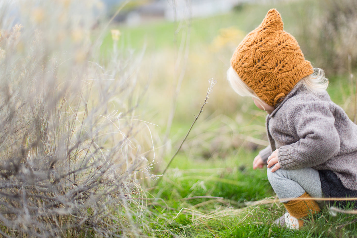 Kid outside wearing a merino wool bonnet by Nooks Design