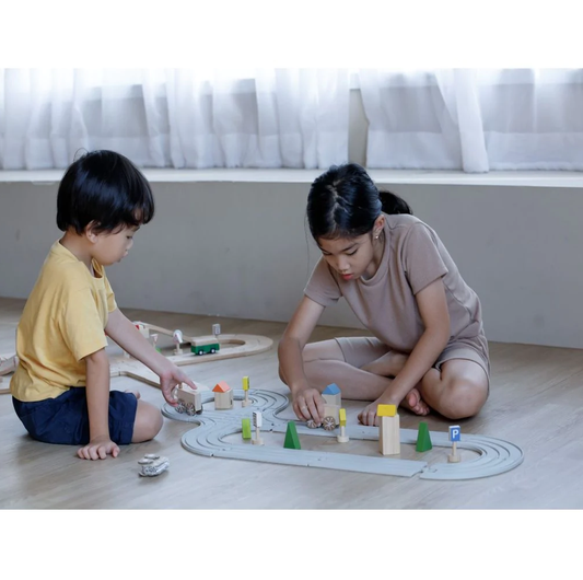 Kids playing with the plan toys rubber railroad set
