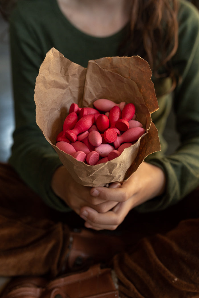 Child holding flower petal mandala in a paper bag