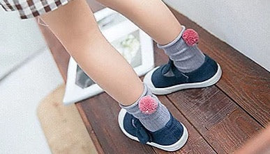 Kid wearing organic pom pom socks