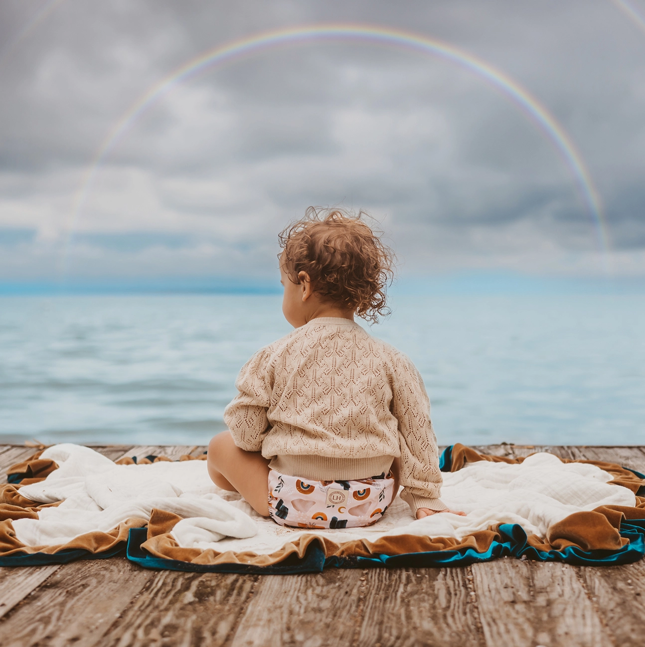 child in moon rainbow diaper